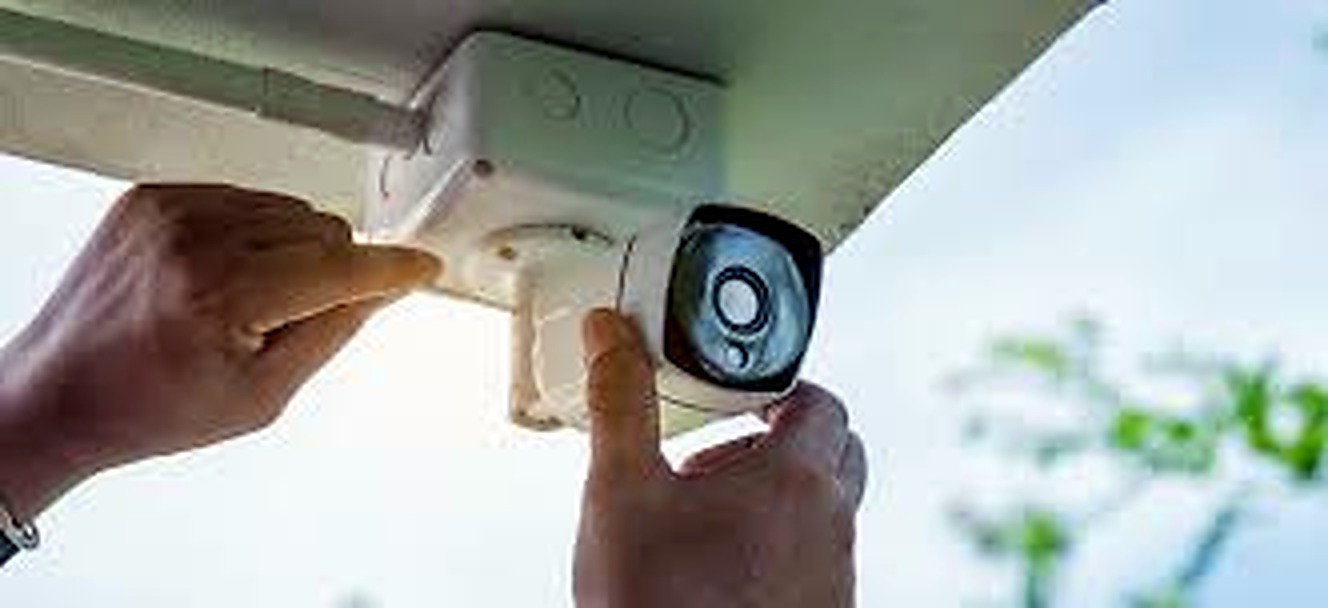 Security camera being installed under an exterior soffit
